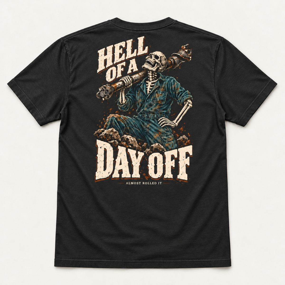 Day Off tee in Vintage Black, back flat lay showing Hell of a Day Off and a skeleton mechanic carrying a driveshaft.