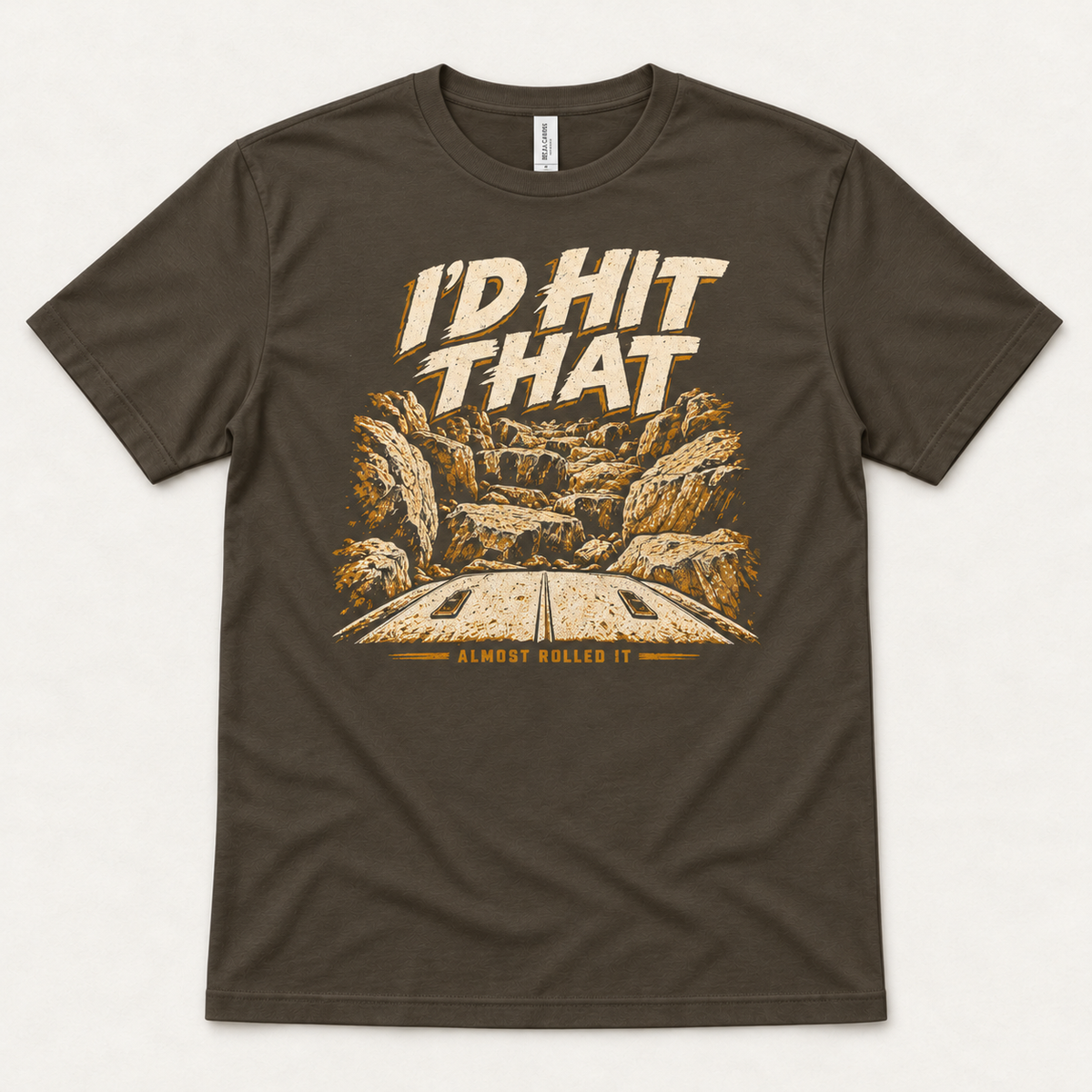 I'd Hit That tee in Army, front flat lay showing the cream-and-mustard rock obstacle graphic viewed over a vehicle hood.