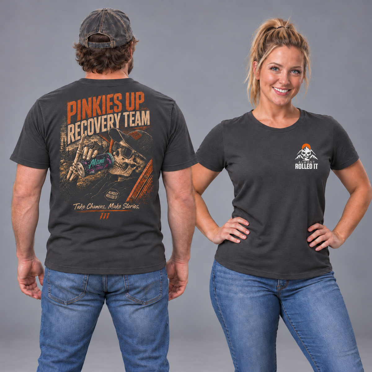 Male back and blonde female front studio views of the Dark Grey Pinkies Up Recovery Team tee, with white-orange ARI chest mark.