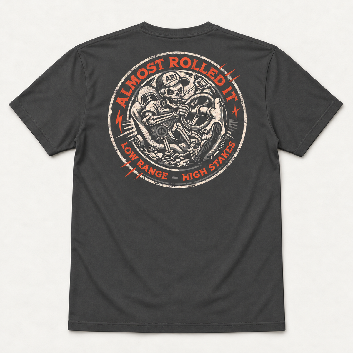 4Lo Skull tee in Dark Grey, back flat lay showing the cream-and-orange Low Range High Stakes skeleton-driver badge.