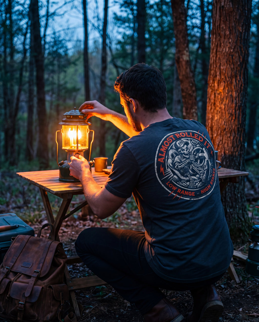 Man in the 4Lo Skull tee lighting a lantern at a campsite