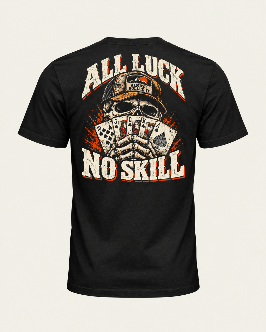 All Luck No Skill tee in vintage black, back view: skull in a trucker cap holding a royal flush of spades, cream and orange lettering