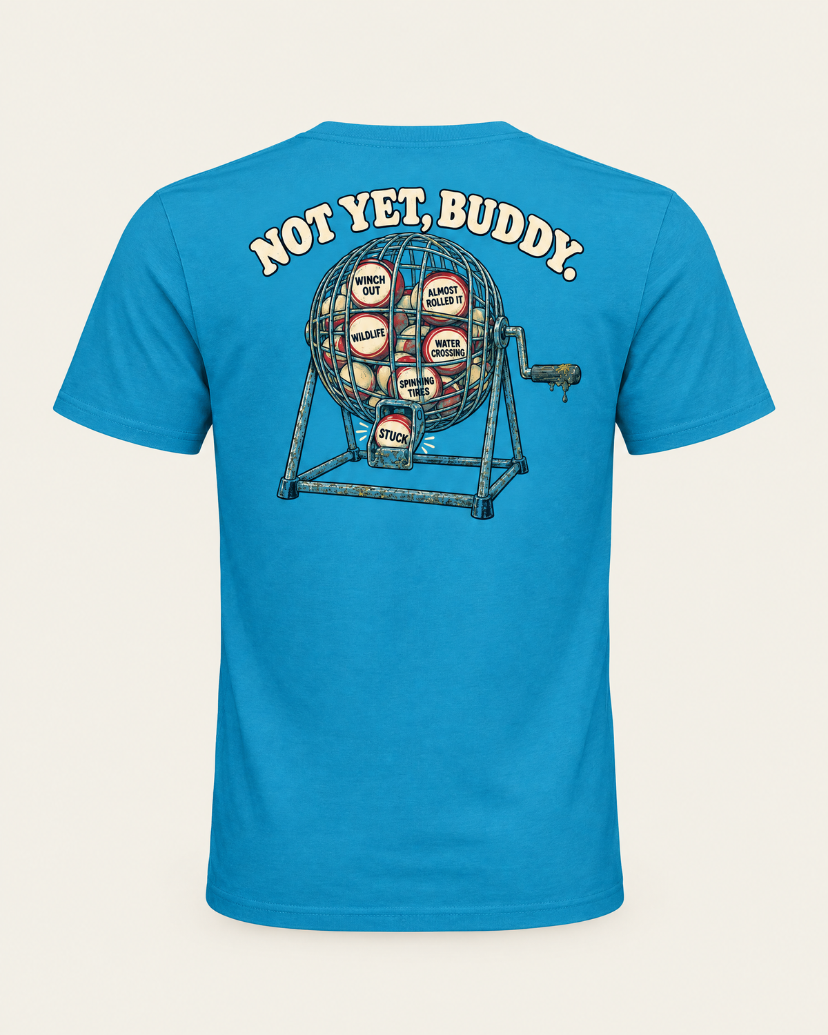 Are We Stuck Yet? tee in electric blue, back view: Not Yet, Buddy over a bingo cage with Stuck dropping out of the chute