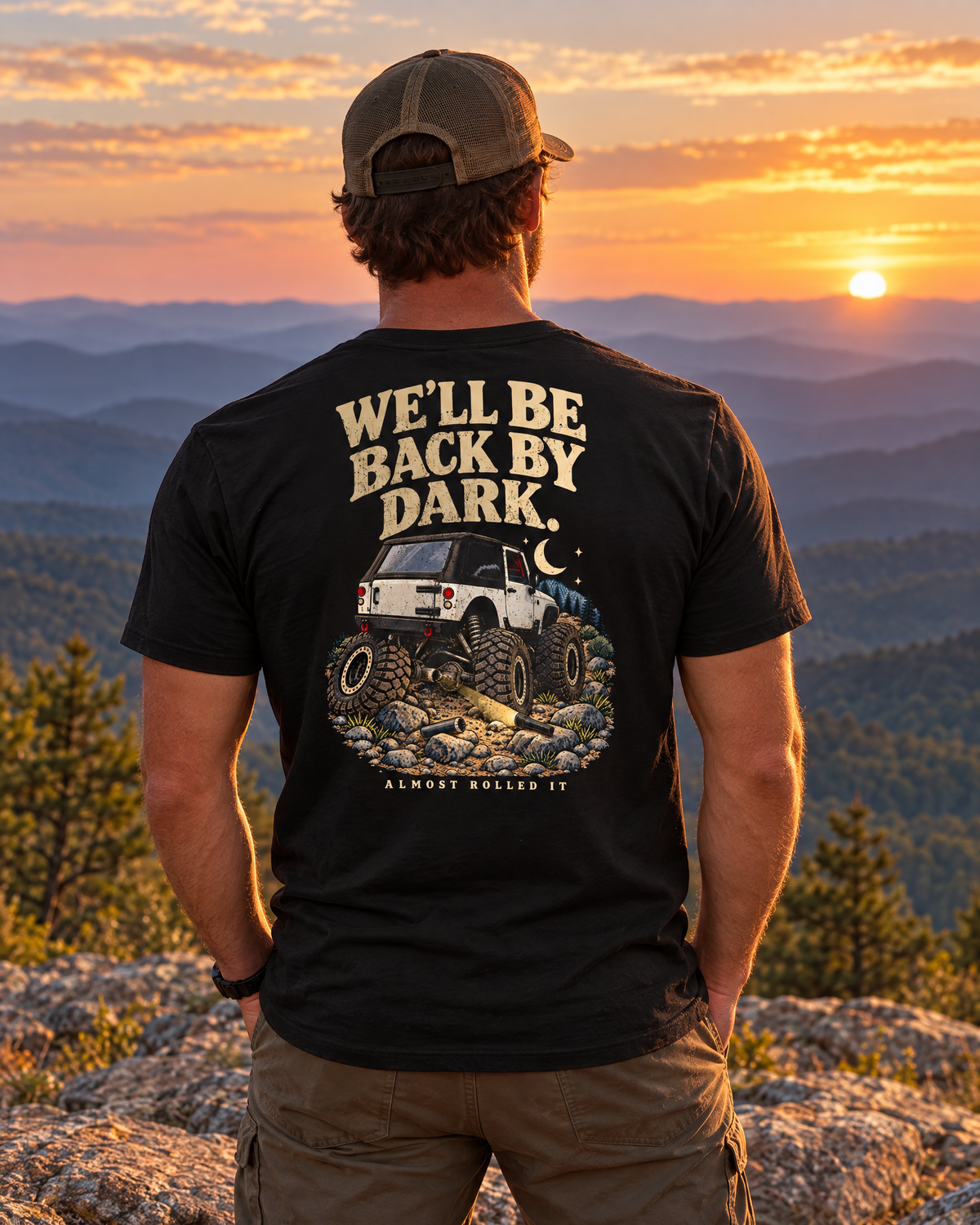 Man on a Blue Ridge ledge at sunset wearing the vintage black Back By Dark tee, back print visible