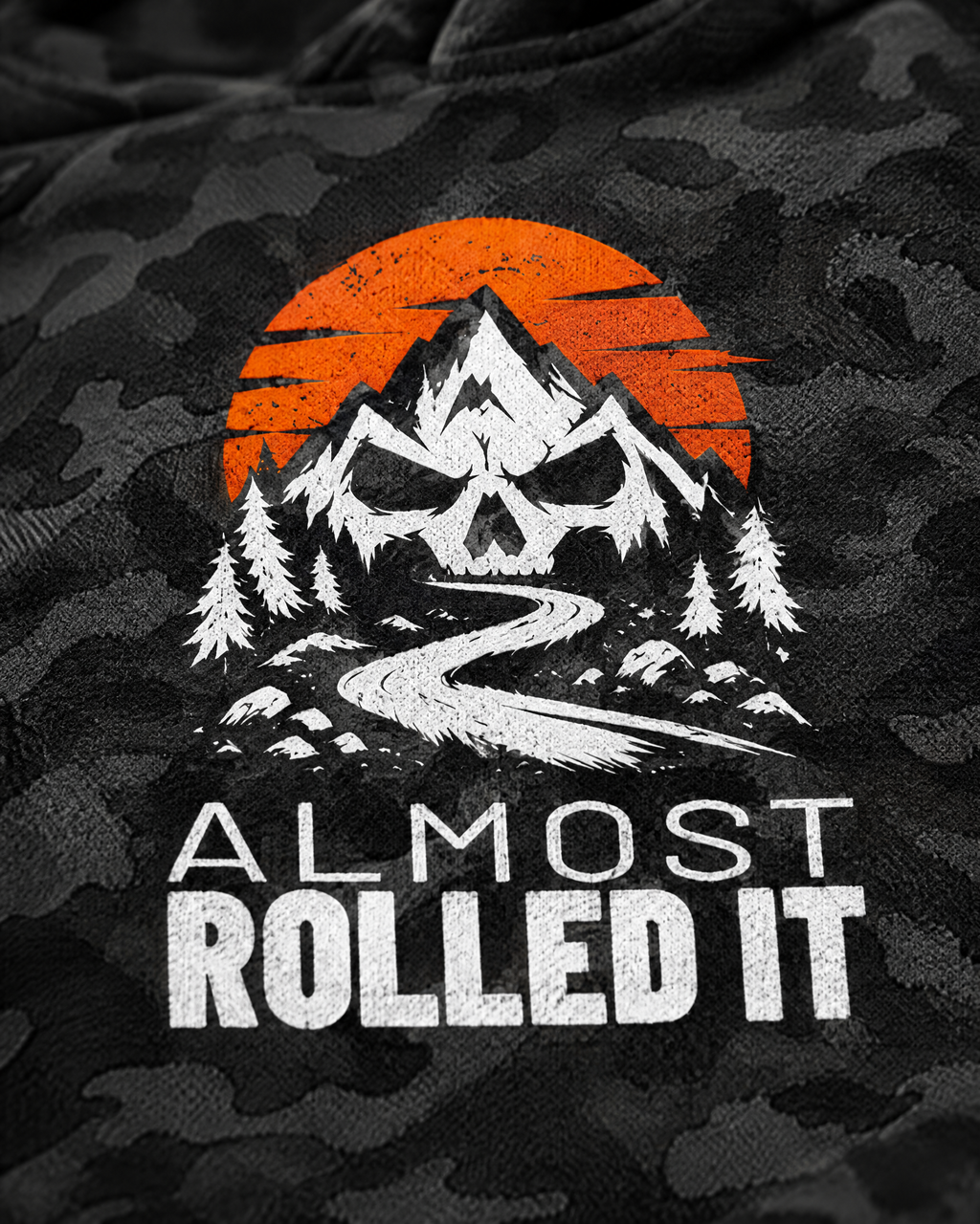 Close-up of the skull-and-mountains Almost Rolled It print on black camo fleece