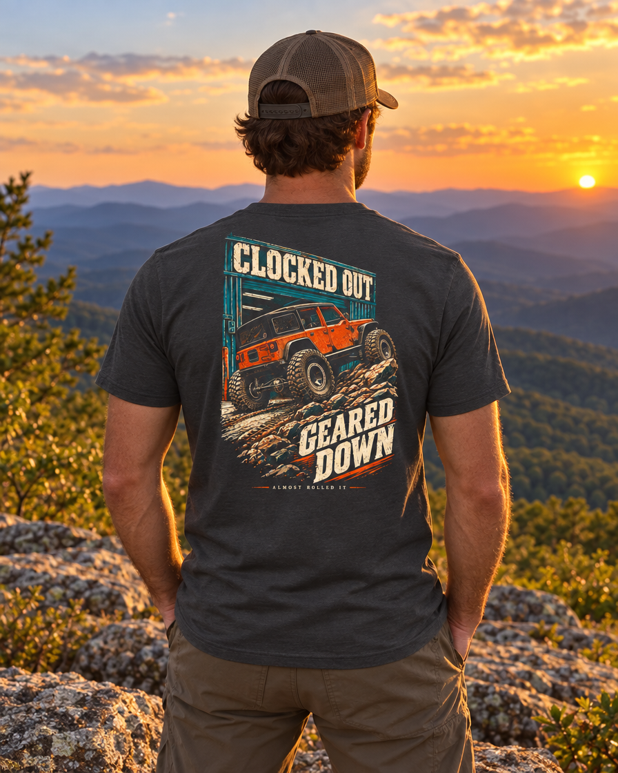 Man on a Blue Ridge ledge at sunset wearing the dark grey Clocked Out tee, back print visible