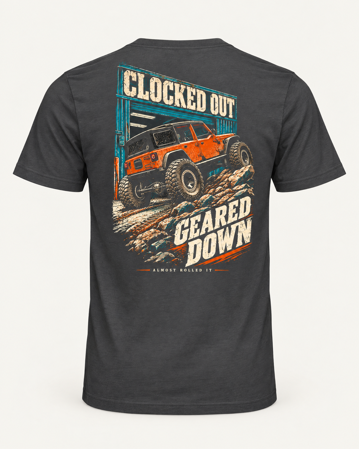 Clocked Out tee in dark grey, back view: cream CLOCKED OUT lettering over a teal garage door, an orange rig rolling out onto rocks, GEARED DOWN below