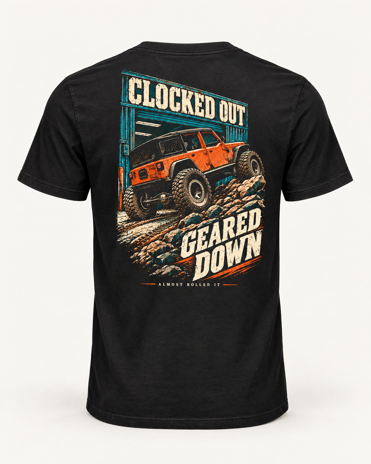 Clocked Out tee in vintage black, back view: cream CLOCKED OUT lettering over a teal garage door, an orange rig rolling out onto rocks, GEARED DOWN below