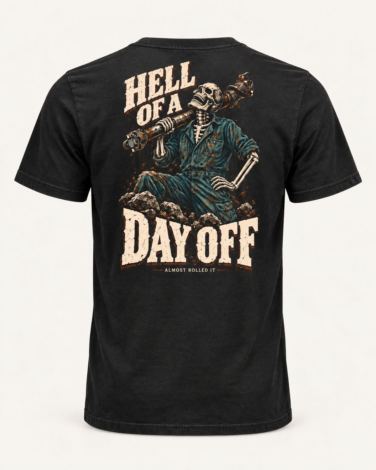 Day Off tee in vintage black, back view: HELL OF A DAY OFF in cream lettering around a skeleton in coveralls with a driveshaft over its shoulder