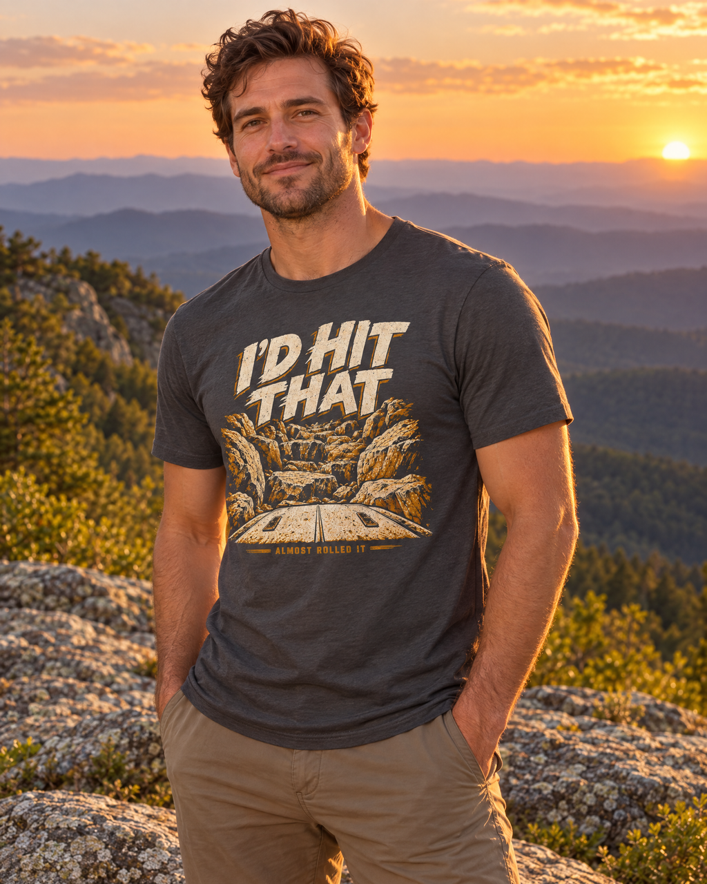 Man on a Blue Ridge ledge at sunset wearing the dark grey I'd Hit That tee, front print visible