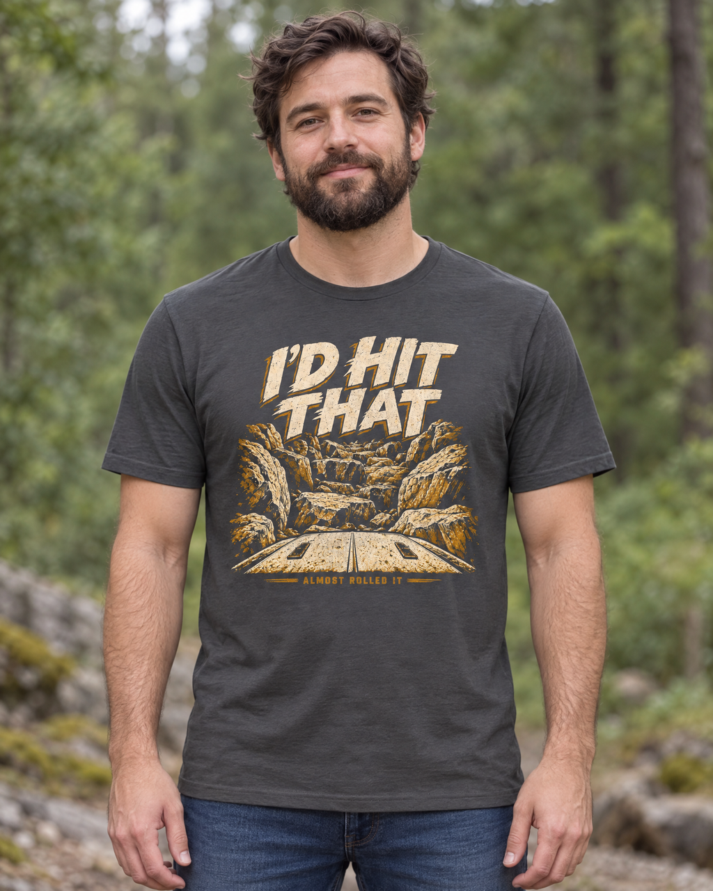 Man in a forest wearing the dark grey I'd Hit That tee, front view