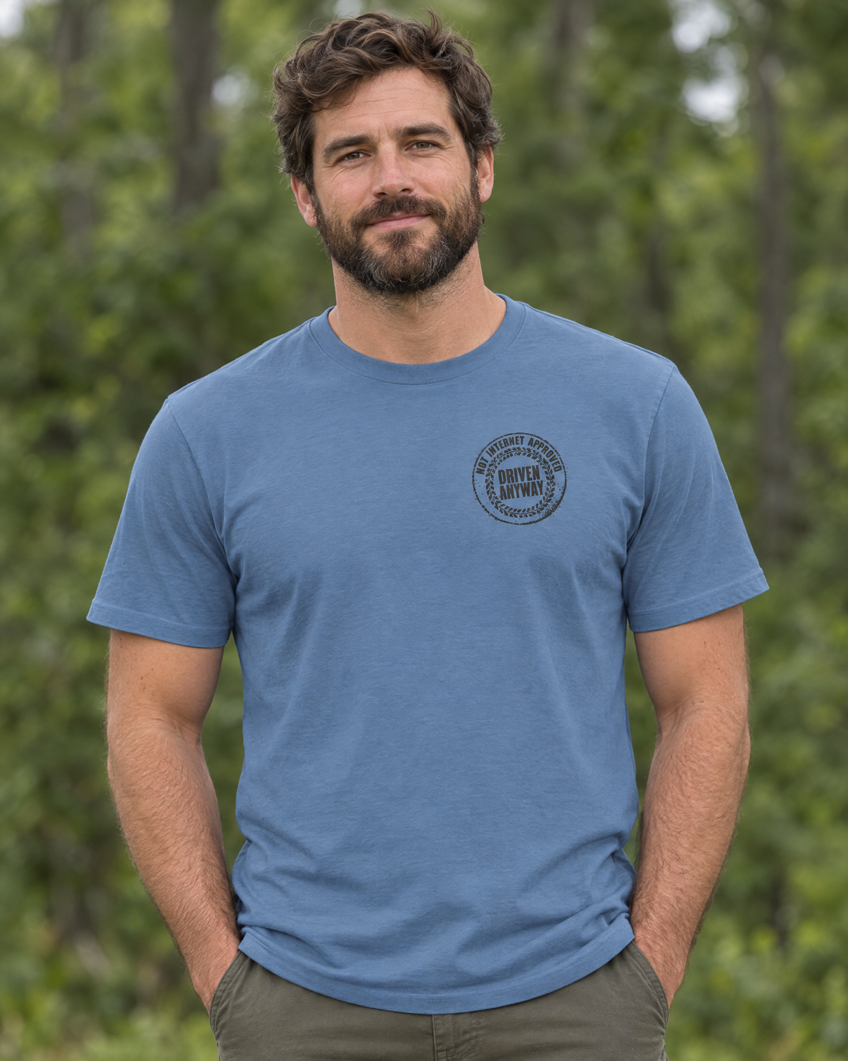 Front of the slate Nobody Asked tee on a model: small round Driven Anyway chest stamp