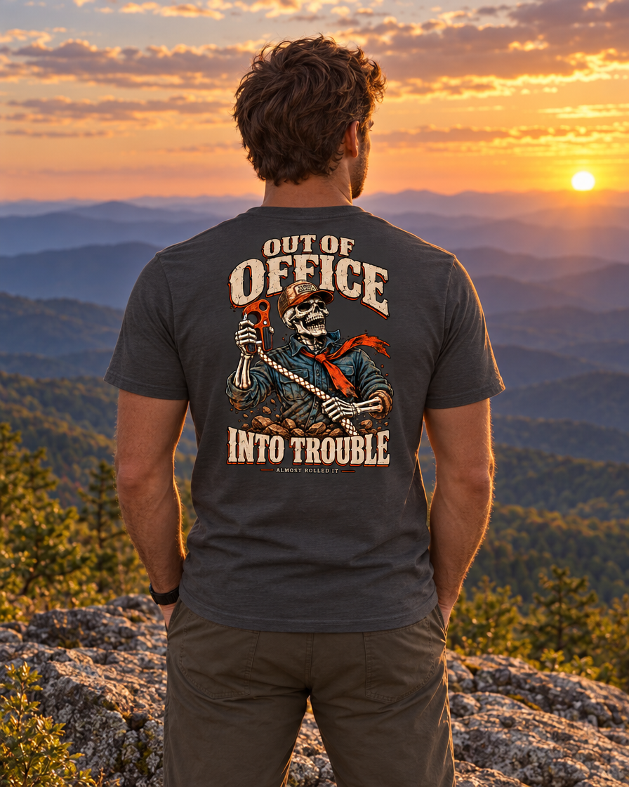 Man on a Blue Ridge ledge at sunset wearing the dark grey Out of Office tee, back print visible