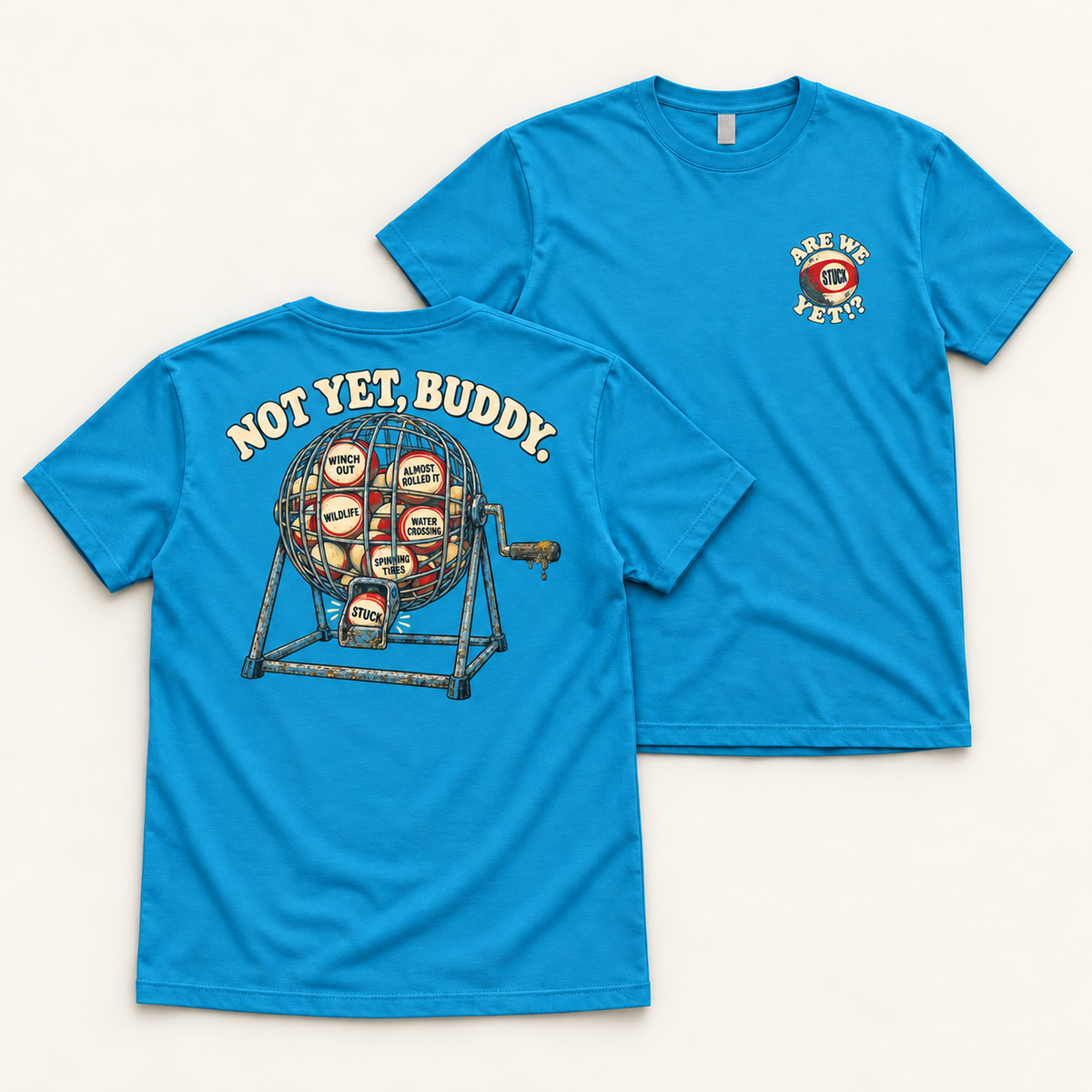 Are We Stuck Yet? adult tee in Electric Blue, paired flat lay showing the back bingo-cage print and front chest badge.