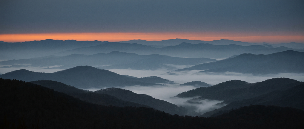 Blue hour over layered Appalachian ridgelines with fog in the valleys