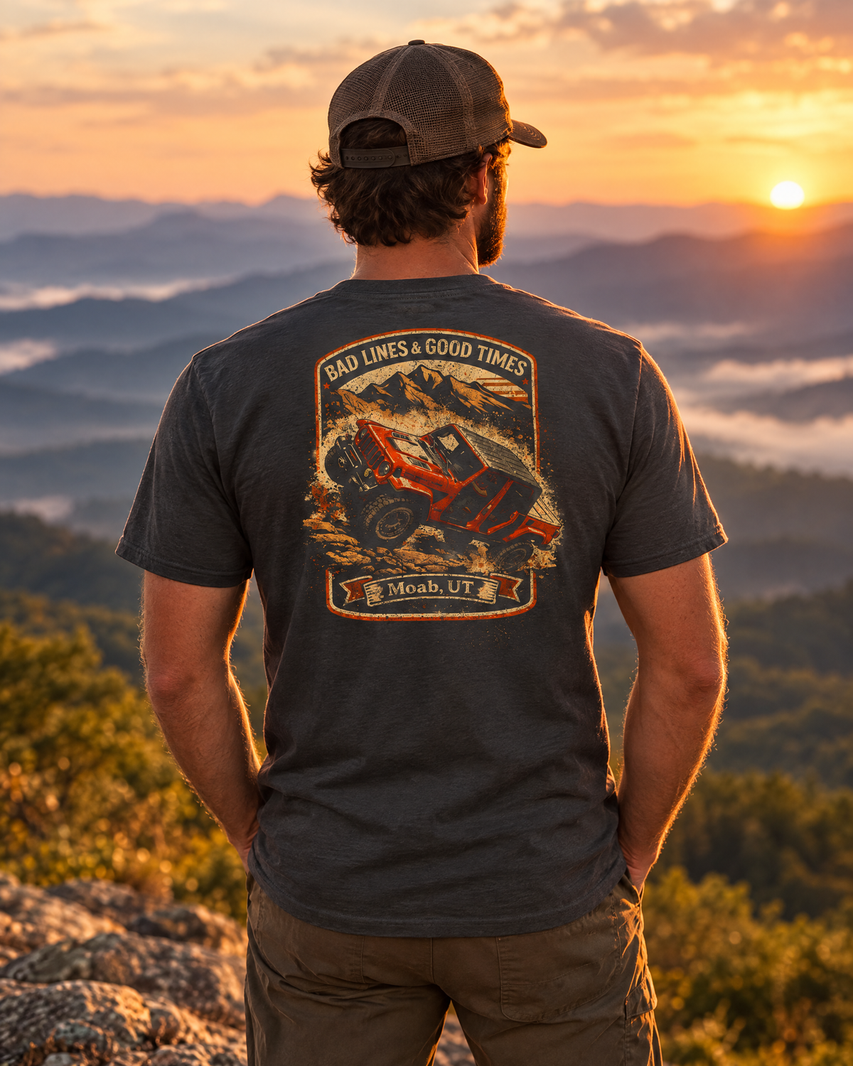 Man wearing the Shibby Bad Lines tee on a mountain ledge at sunset, back badge showing