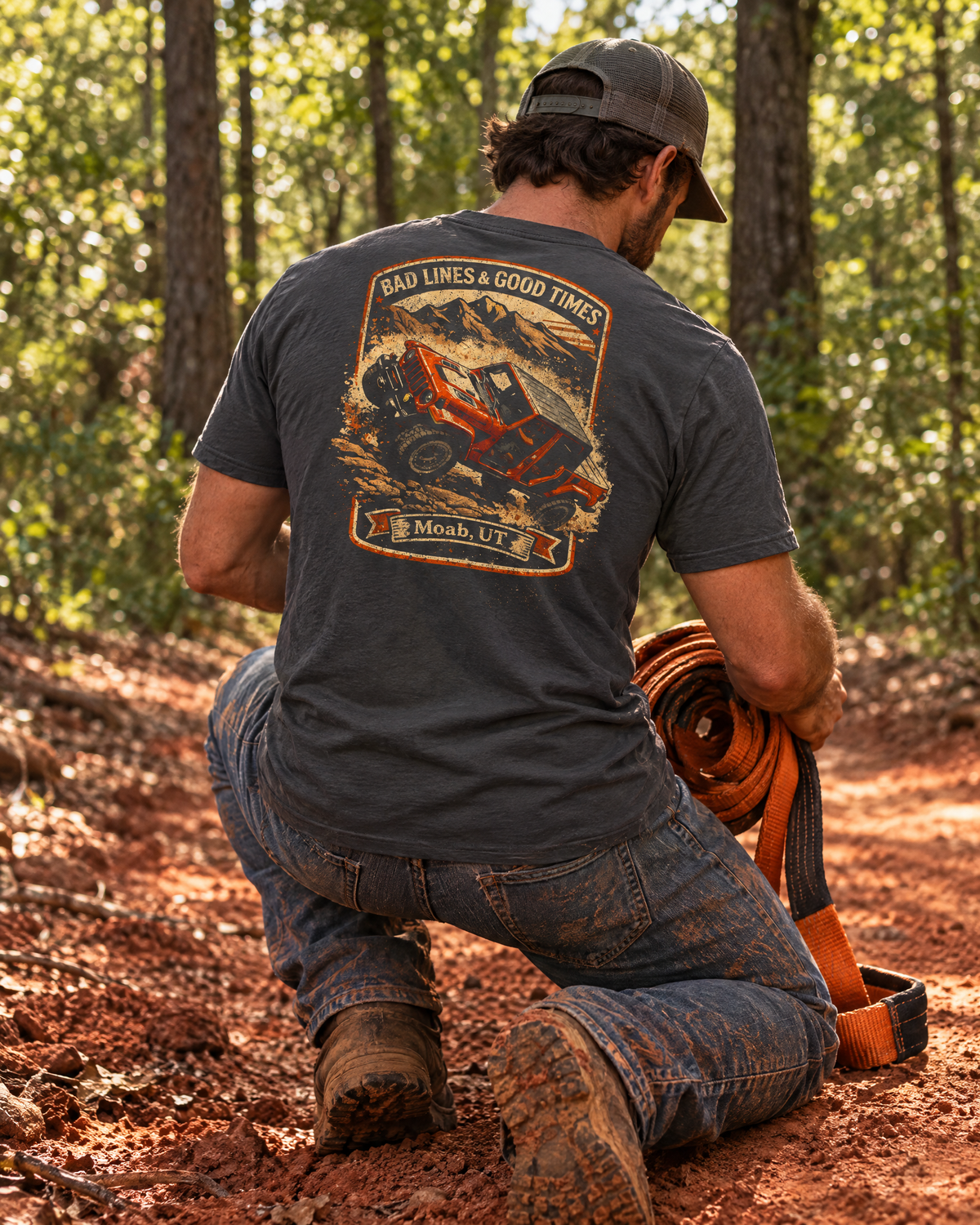 Man kneeling on a red-clay trail in the Shibby Bad Lines tee