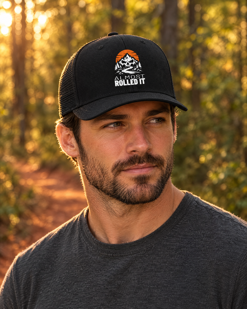 Man wearing the black Almost Rolled It trucker hat on a forest trail at golden hour