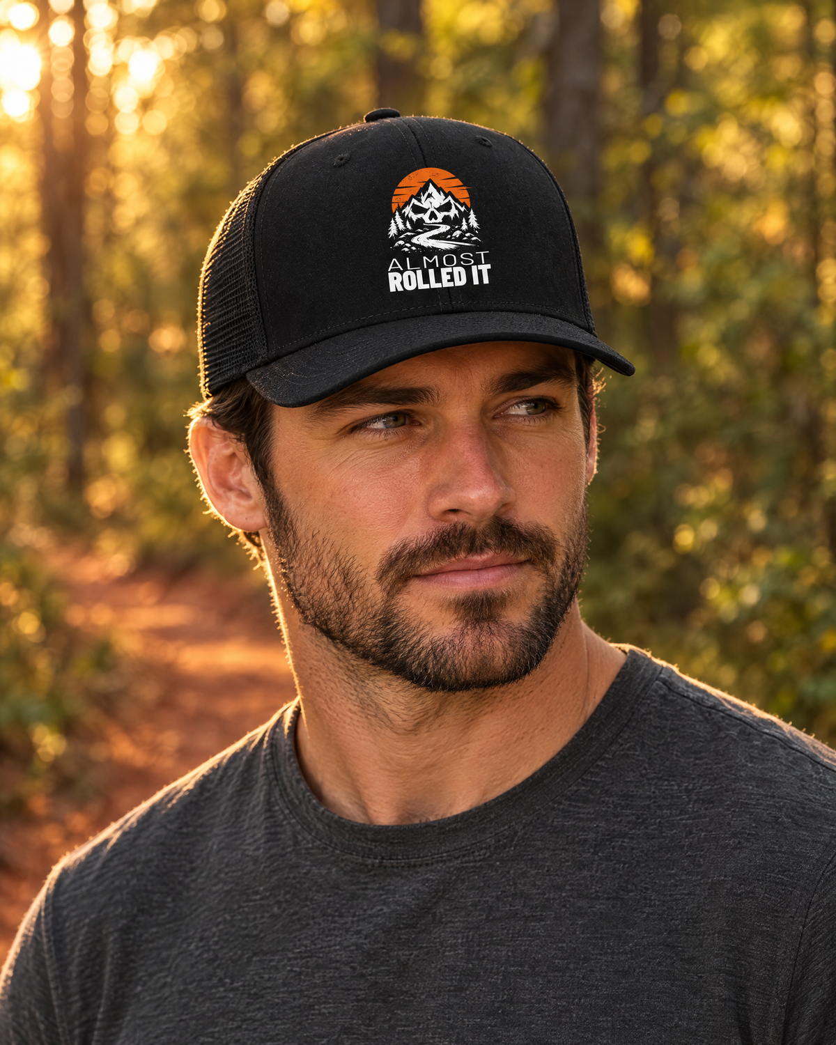 Man wearing the black Almost Rolled It trucker hat on a forest trail at golden hour