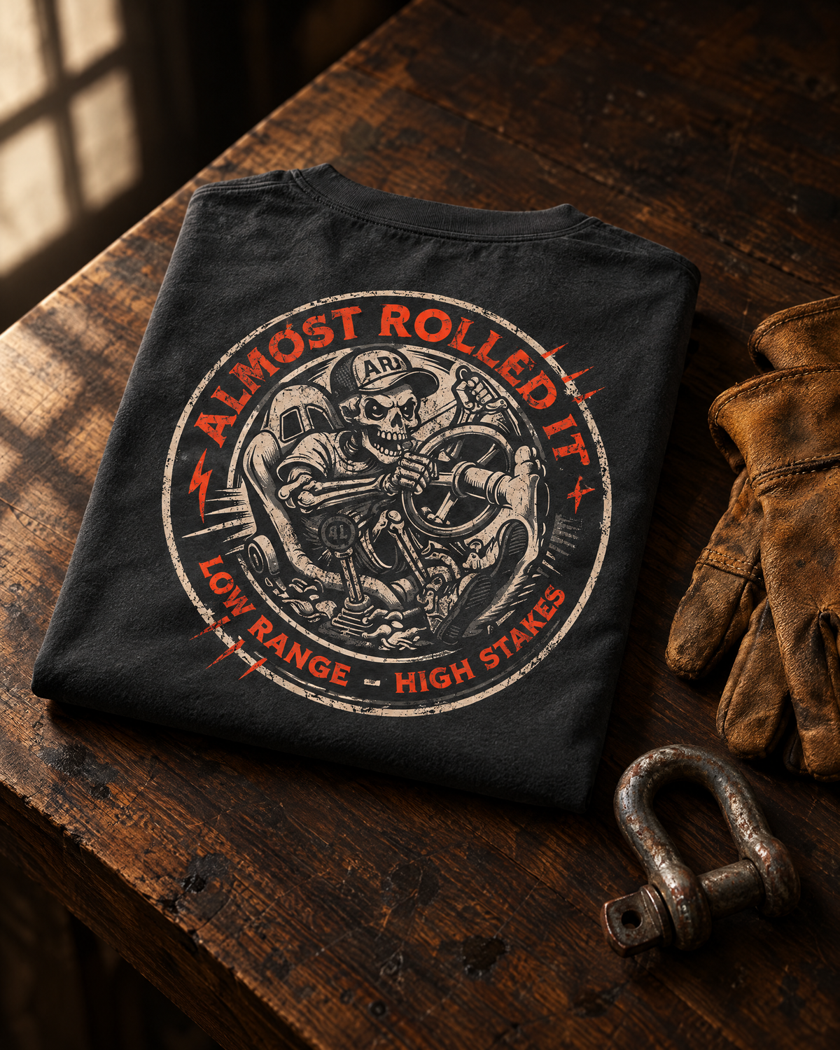 4Lo Skull tee folded on a walnut workbench next to leather gloves and a shackle