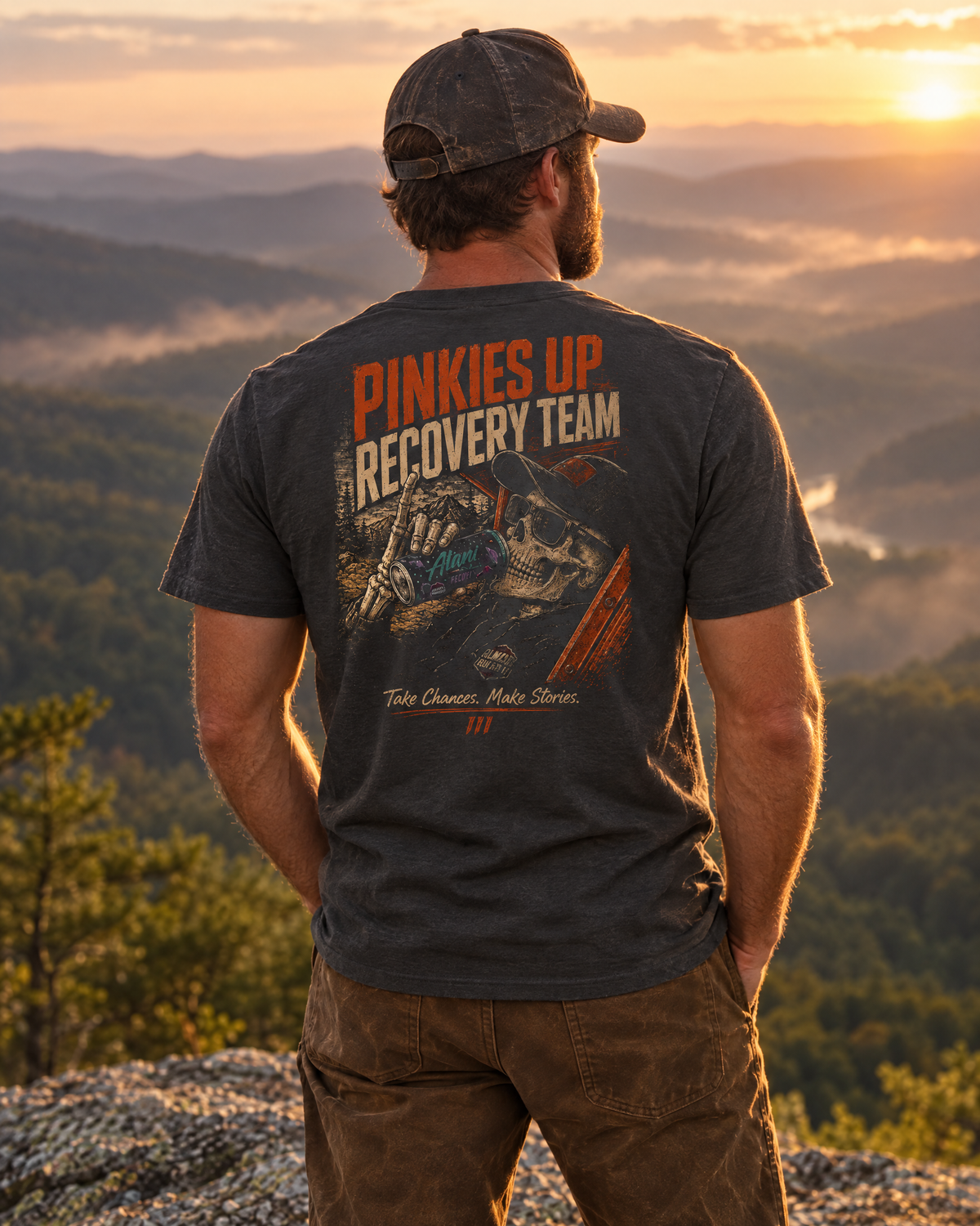 Man wearing the Pinkies Up tee on a mountain ledge at sunset, back print showing