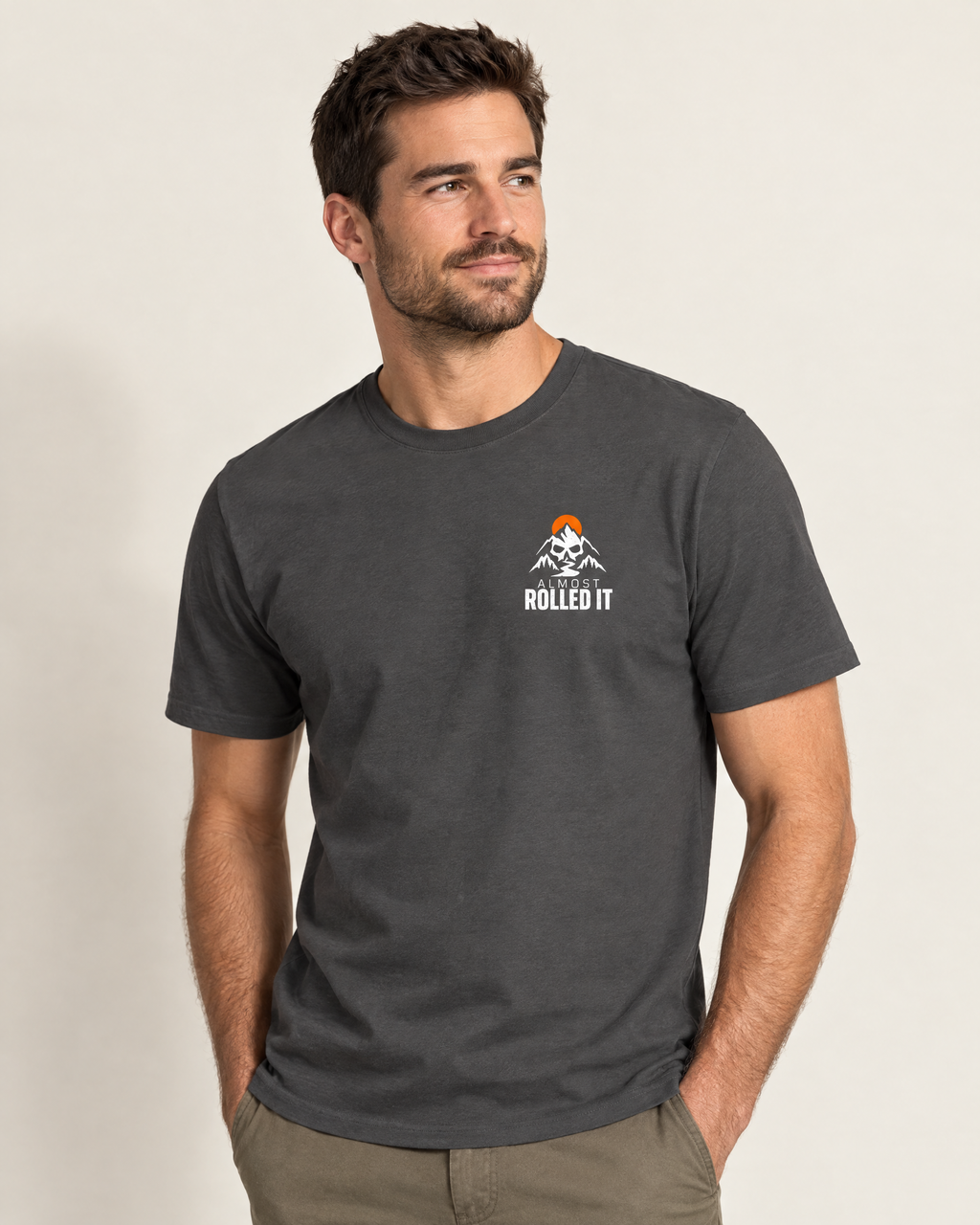Front of the Pinkies Up tee on a model: small skull-and-mountains Almost Rolled It chest logo