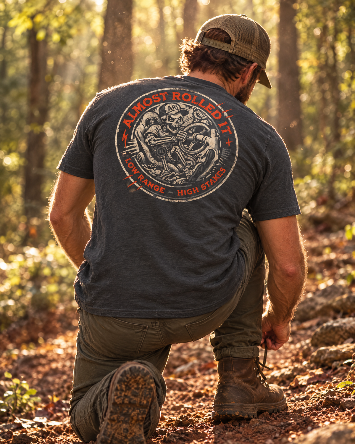 Man kneeling on a red-clay trail in the 4Lo Skull tee