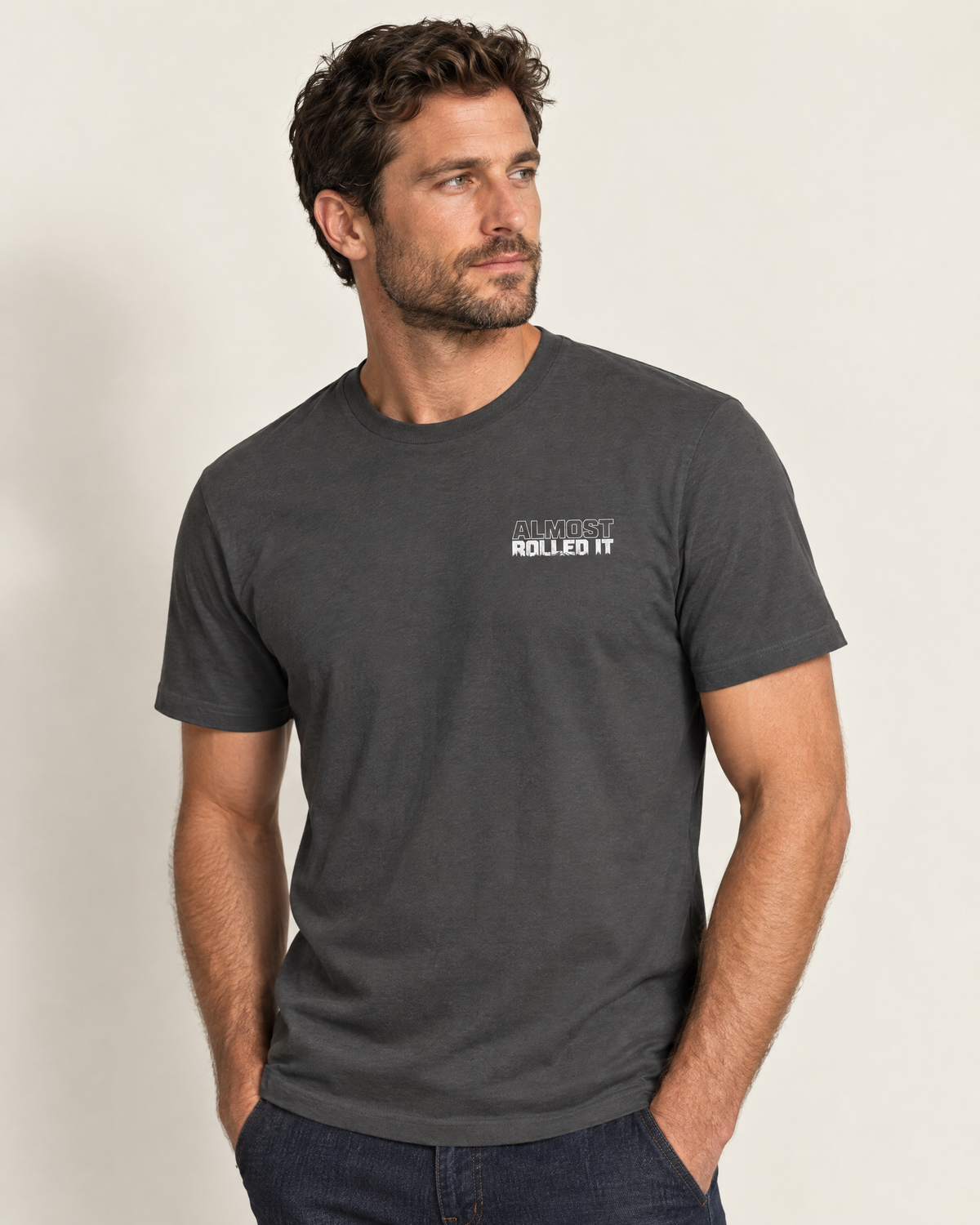 Front of the dark grey Tons & 42s tee on a model: small white Almost Rolled It wordmark
