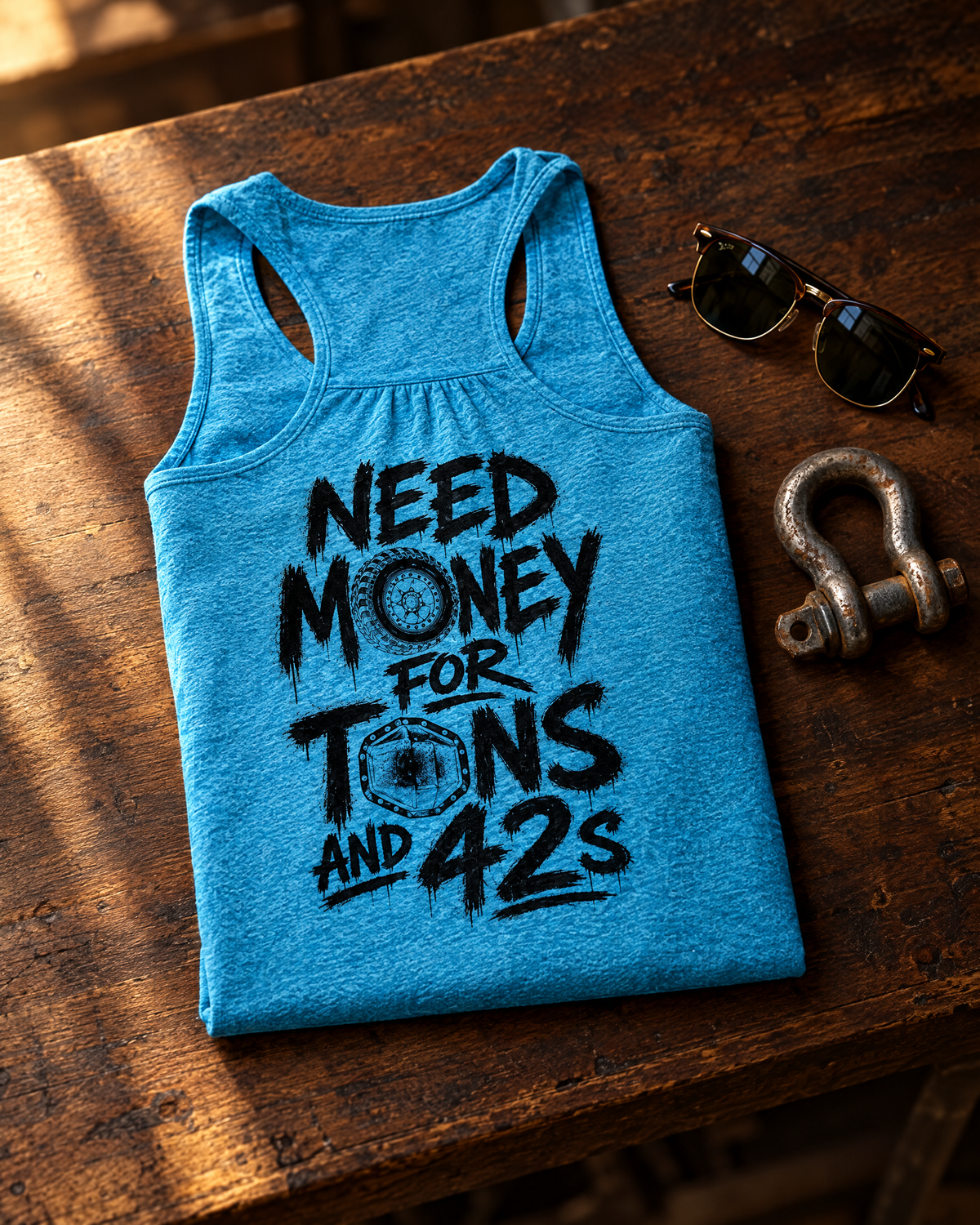 Tons & 42s tank laid on a walnut workbench next to sunglasses and a shackle